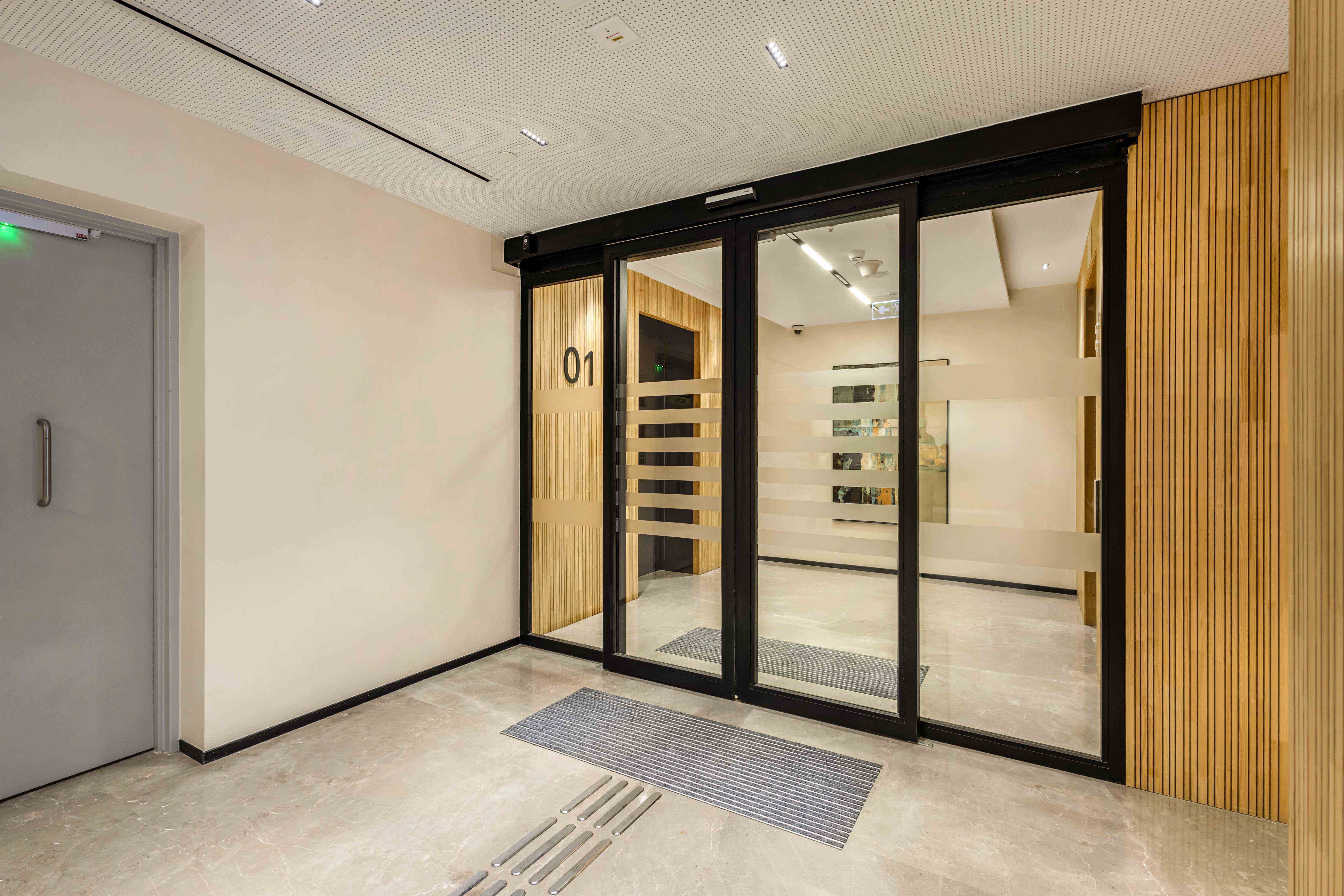 Brookfield’s fire-rated sliding glass doors with black frames and frosted stripes by Vetrotech.