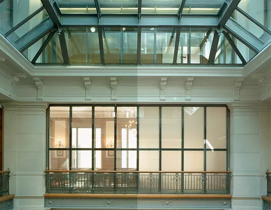 Priva Lite Customized glass panels within an architectural interior, featuring a skylight and balcony with railings.