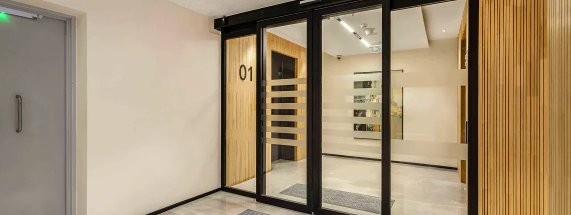 Brookfield’s fire-rated sliding glass doors with black frames and frosted stripes by Vetrotech.