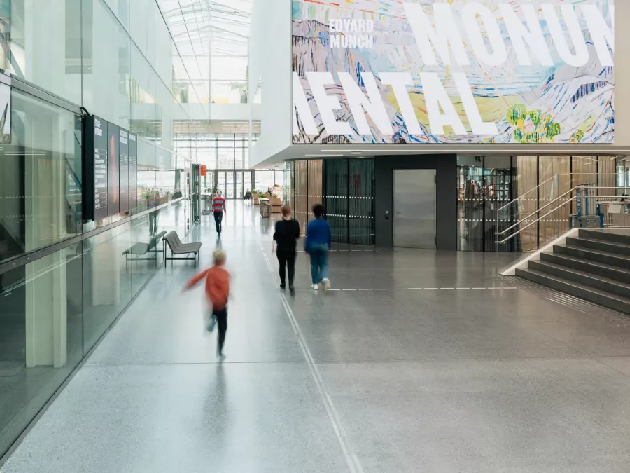 Modern museum interior with a large banner displaying 'Edvard Munch Mental' exhibition
