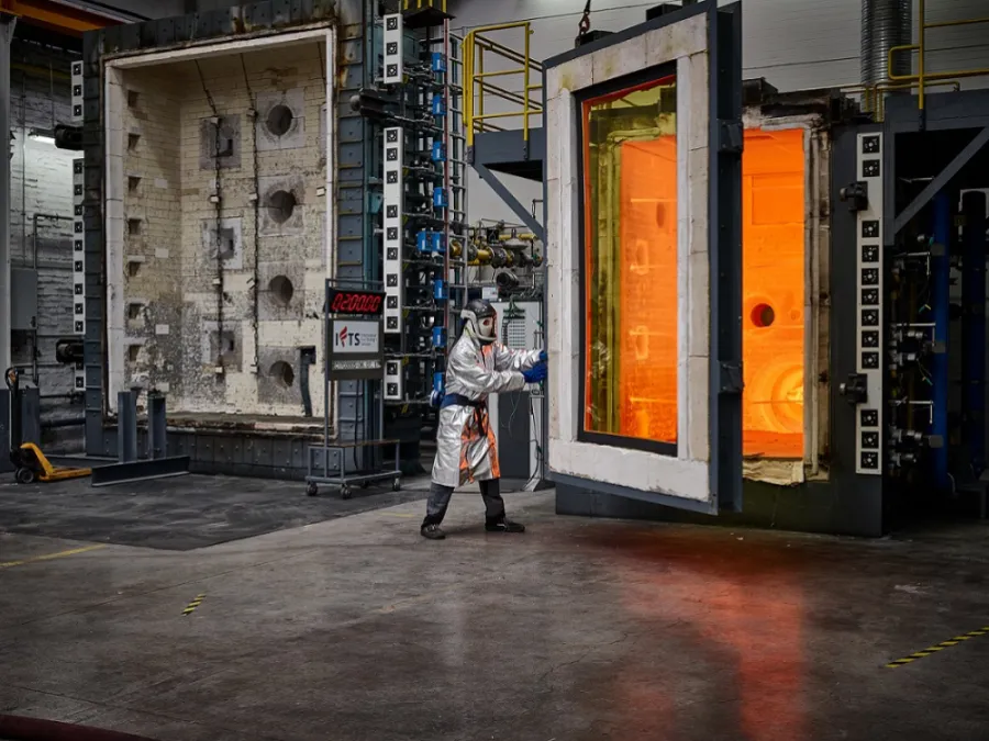 Fire resistance testing in a laboratory with a person in a protective suit standing between two large furnaces