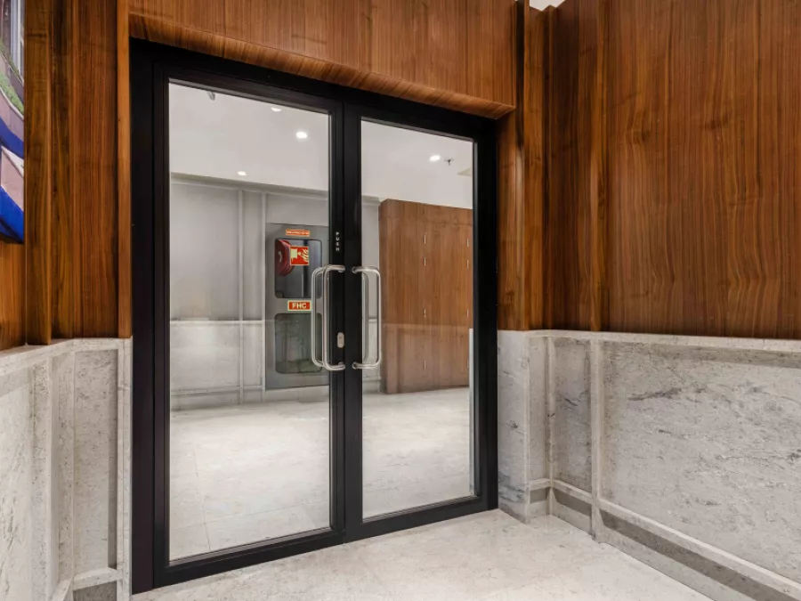 Fire-rated glass door, in a hallway with wood paneling and a light-colored floor.