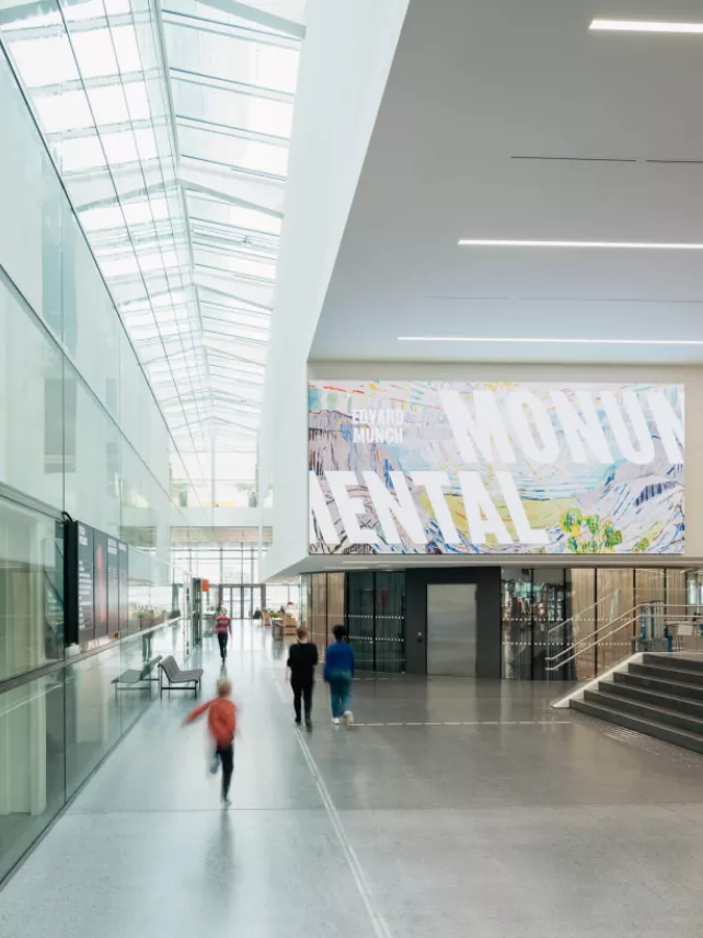 Modern museum interior with a large banner displaying 'Edvard Munch Mental' exhibition