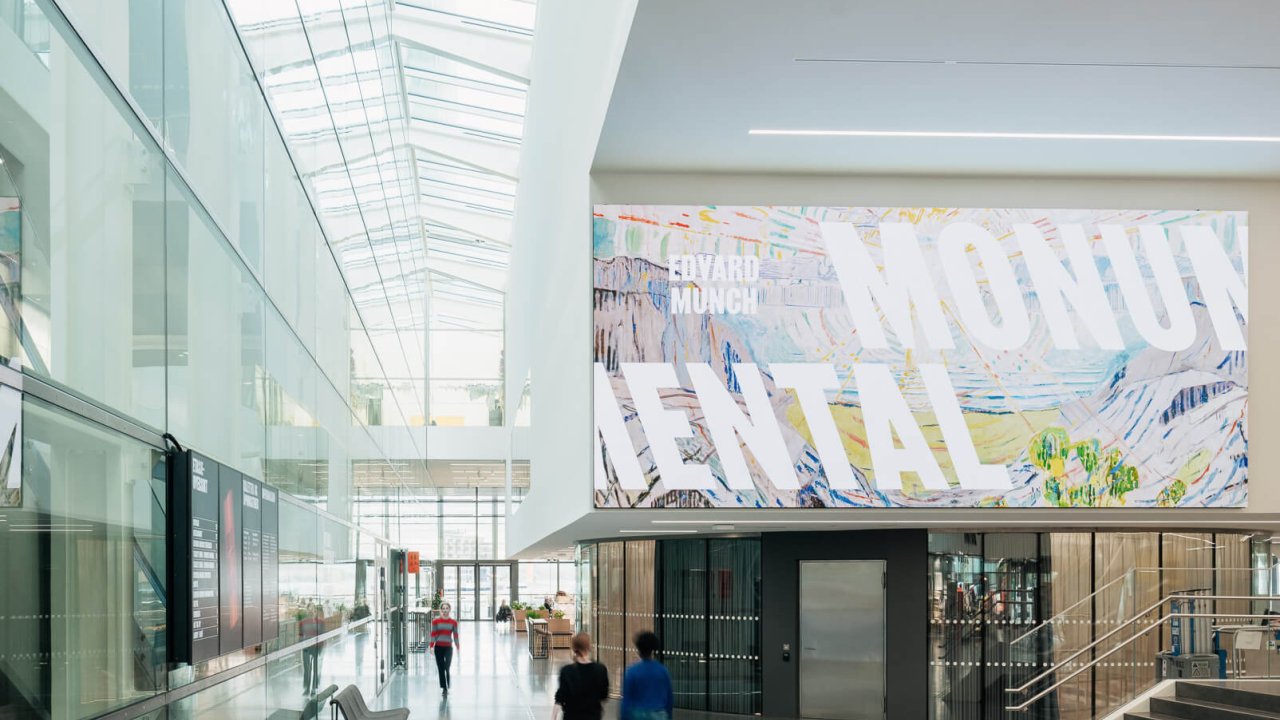 Modern museum interior with a large banner displaying 'Edvard Munch Mental' exhibition