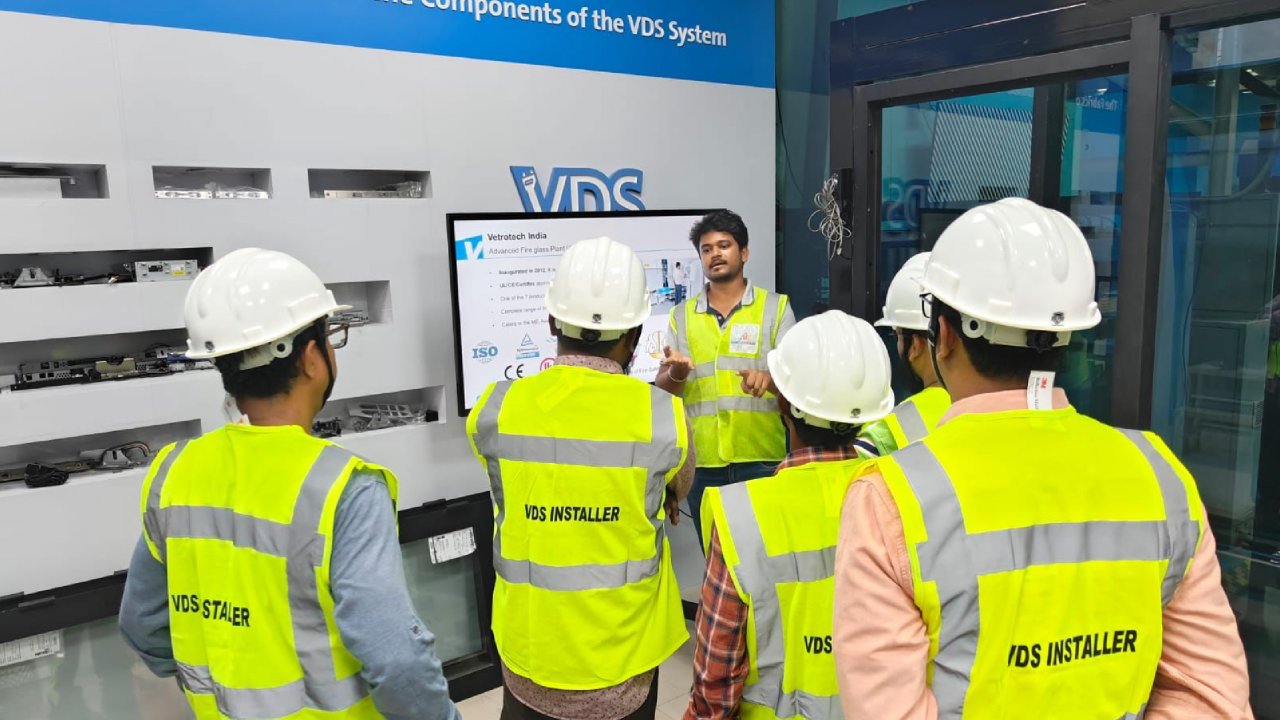 Five people in hard hats and safety vests viewing a screen displaying VDS-related information.