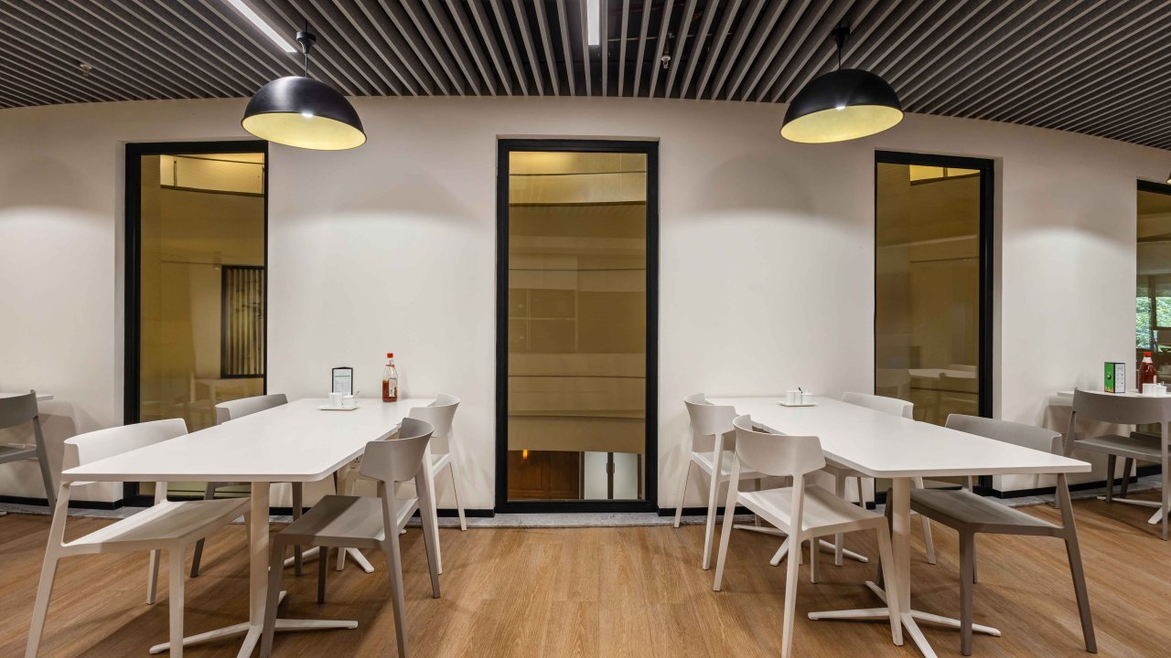 Cafeteria interior at Brookfield Properties featuring fire-resistant glass partitions framed in black.