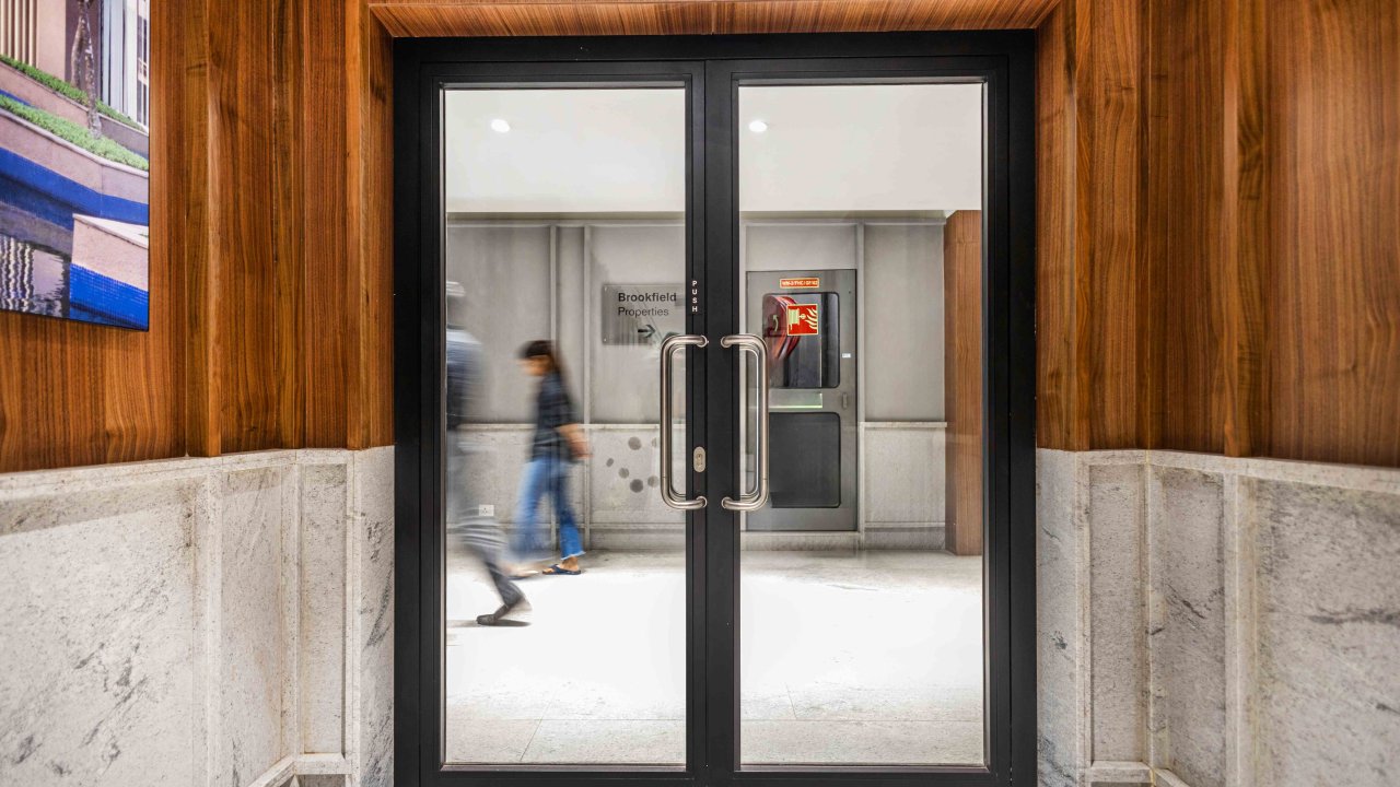 Double leaf fire proof glass doors with black metal frames, leading to an interior space.